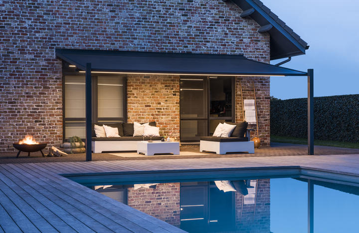 Suncomfort - Lapure - Renson - terrasoverkapping met openschuivend windvast doek - sfeerverlichting - avondbeeld